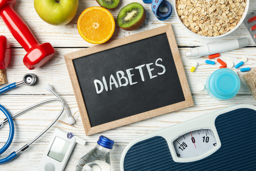 Word Diabetes and diabetic accessories on wooden background
